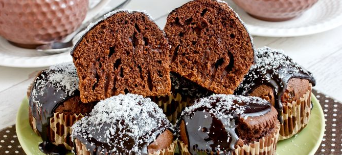 Chocolate cupcakes with raisins, icing and coconut sprinkles